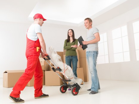 Removal team pricing a small apartment move with boxes and furniture